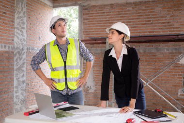 Ekip mimarı veya mühendis erkek ve kadın inşaat alanında emlak planlaması ve stratejisi için buluşuyorlar, müteahhit ve ortak konuşuyor ve arıyor, endüstriyel konsept.