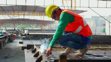 Endüstriyel fabrikada çalışan, kaynak makinesi kullanan Asyalı genç işçiler, kaynak makinası, kaynak makinesi, kaynak makinesi, çelik işçisi, parıltı, işgal teknisyeni ve beceri, endüstri konsepti..