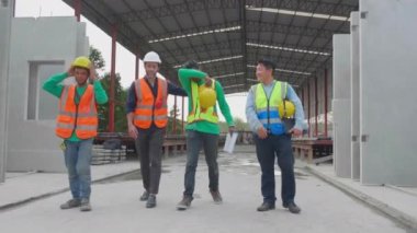 Grup mühendisi ya da müteahhit sabit şapka tutuyor inşaat sahasında, mimar ve işçi tartışmalarında mutlu bir şekilde sohbet ederken mola ve eğlence birlikte, takım çalışması ve endüstriyel konsept.