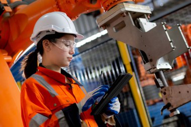 Genç Asyalı mühendis kadın denetim robotu silahlandırıyor teknoloji zekası ve yenilik fabrikada dijital tablet, teknisyen kontrol ve bakım robotu, endüstriyel konsept.