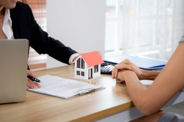 Menajeriyle ev satın alma sözleşmesi ve ipotek sözleşmesi hakkında konuşan genç bayan müşteri ve planlama için ofis, finans ve yatırım, iş konsepti.