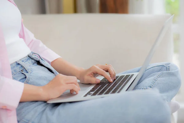 stock image Closeup hands business woman work from home with laptop computer online to internet on sofa in living room, freelance girl using notebook sitting on couch with comfort and relax, lifestyles concept.