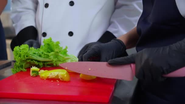 厨师们在厨房里一起切碎甜椒 在厨房里一起做饭 男人们训练和讨论女店员准备菜谱的技巧 — 图库视频影像