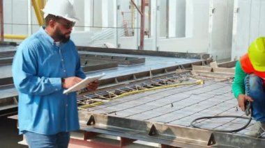 Endüstriyel fabrikayı, kaynakçıyı ya da işçiyi incelerken makineli kaynak demiri kullanan genç Asyalı işçi, yönetici kontrol ederken kaynak makinesi kullanıyor, endüstri kavramı.
