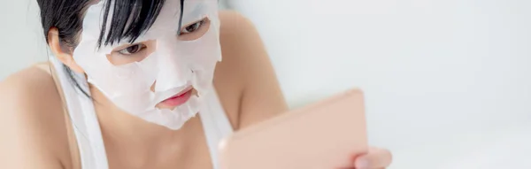 Beautiful Young Asian Woman Sheet Facial Mask Lying Watching Tablet — Stock Photo, Image