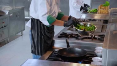 Şef Asyalı 'nın yakın çekim elleri, yemek ve beslenme, ünlü, aşçı ve yemek tarifli Tayland yemeği ve restorandaki tavada kızartma hazırlamak için sabah ihtişamı üzerine baharat koyun..