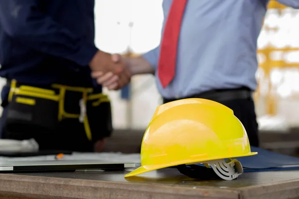 Young engineer caucasian man handshake with partner while negotiation about agreement success together at construction site, architect and partnership deal and shaking hands for developer real estate.