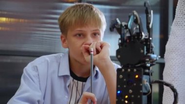 Kafkas asıllı iki genç öğrenci okulda robotik kolu birlikte öğreniyor, erkek ve kız kontrolör olarak robot yapay zeka üzerinde çalışıyor ve öğretmenlik, eğitim ve geliştirme kavramını kullanıyor..