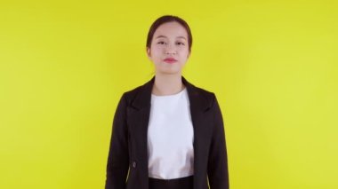 Sarı arka planda izole edilmiş ve beğenilmeyen Asyalı genç iş kadını portresi, reklamcılık ve pazarlama, stres ve hüsran, iş kadını sıkılmış ve dışavurumdan hoşnut olmayan.