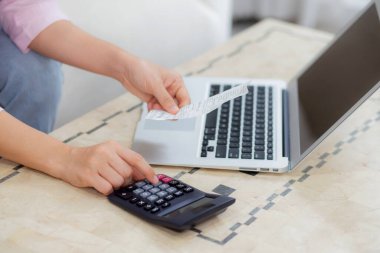 Mali ev işlerini evde hesap makinesiyle hesaplayan kadının elleri, tasarruf ve planlama masrafları, borç ve kredi, vergi ve muhasebe, iş ve mali işler için faturaları kontrol eden kız.