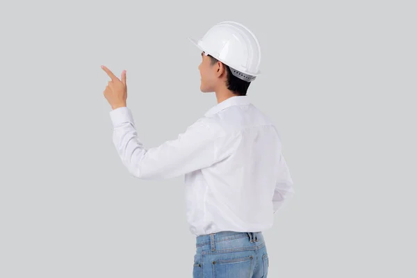 ポートレート若いアジアの男はヘルメットスタンドを身に着けているエンジニアであり 自信を持って隔離された白い背景を持つ 男性は何かを提示または示す建築家や請負業者 産業概念 — ストック写真
