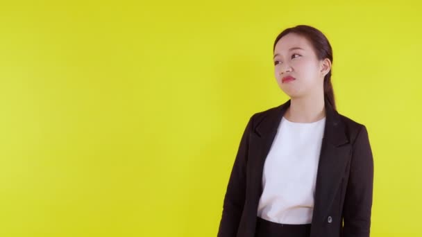 肖像画不幸な若いアジアのビジネス女性を提示し 黄色の背景に孤立嫌い 広告やマーケティング ストレスや不満 ビジネス女性退屈と表現に不満 — ストック動画