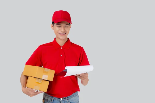 身穿制服的亚洲年轻人 头戴红色帽子 头戴红色礼帽 头戴独立的白色背景文件 员工持有包裹 快递和送货 运输和服务 物流和货运 — 图库照片
