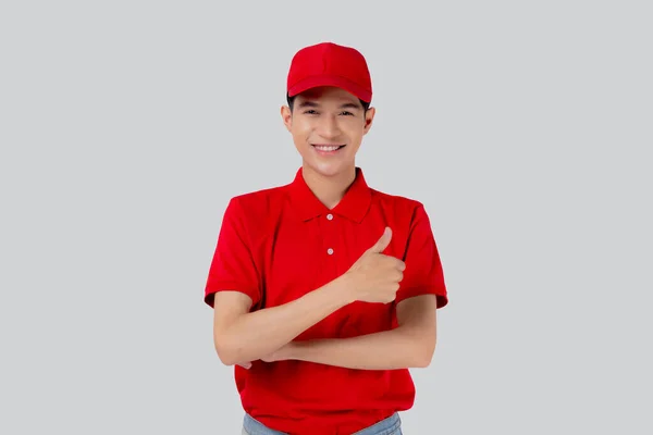 身穿制服红帽子的亚洲年轻人竖起大拇指 自信地与白人背景 员工或经销商 快递员和送货员 送货员和快递员 物流和货运员隔离在一起 — 图库照片