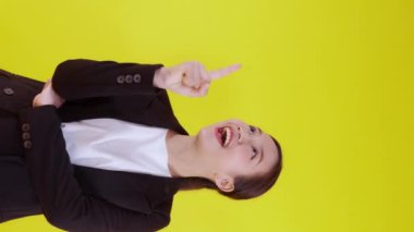 Sarı arka planda izole edilmiş genç Asyalı iş kadını portresi, reklamcılık ve pazarlama, kadın sürprizi ve heyecanı, iş kadını kendine güvenen ifade ile başparmak işareti.