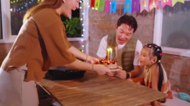 Mutlu Asyalı aile babası, anne ve kızı restoranda yemek yerken doğum gününü kutluyorlar, anne ve baba tatilin, akrabalığın ve bağlanmanın tadını çıkarıyorlar, yaşam tarzı konsepti.