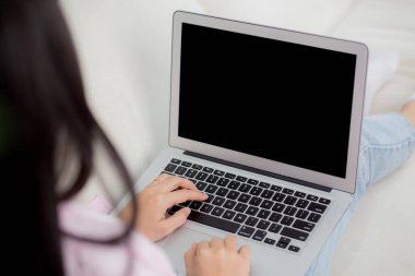 Genç Asyalı kadın evde dizüstü bilgisayarlı boş ekran maketi ile çalışıyor, serbest çalışan kadın boş ekranlı defter kullanıyor, klavye, iş ve iletişim konsepti yazan kız..