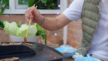 Yakın çekim Asyalı aile babası, anne ve kızı restoranda yemek yerken doğum gününü kutluyorlar, anne ve baba birlikte yemek yiyorlar..