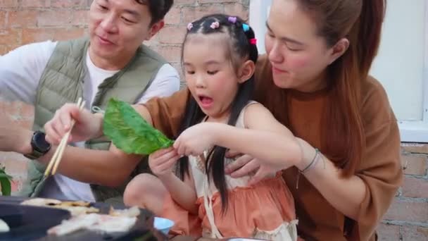 お祝いの誕生日 お母さんとお父さんが休暇で楽しむ食事をしながら 幸せなアジアの家族の父と母と娘はレストランで食べ物を食べる 関係と結合 ライフスタイルの概念 — ストック動画
