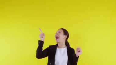 Sarı arka planda izole edilmiş genç Asyalı iş kadını portresi, reklamcılık ve pazarlama, yönetici ve yönetici, iş kadını kendini ifade eden bir şey gösteriyor..