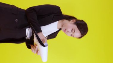 Asyalı genç iş kadını portresi sarı arka planda izole edilmiş bir not, ajan iş kadını veya sekreter planlama ve imza belgesi, pazarlama ve finansal konsept.