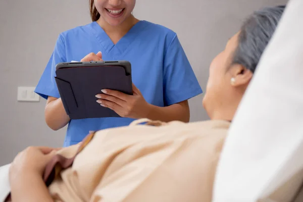 Nurse Writing Report Document Medical Health Care Tablet While Explaining — Stock Photo, Image