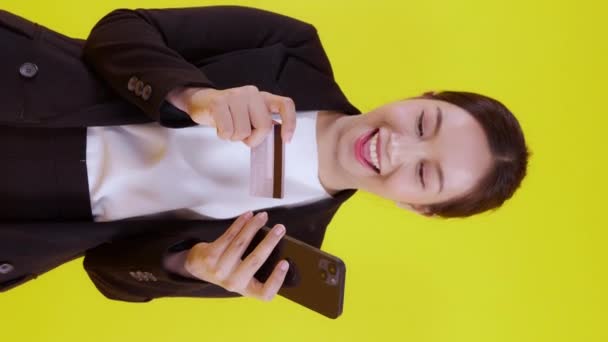 아시아 사업가가 카드를 소지하고 온라인에서 고립된 노란색 배경으로 쇼핑을 수있는 — 비디오