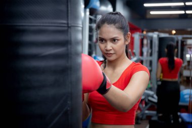 Genç Asyalı kadınların spor salonunda motivasyon boksu, aktif spor ve antrenman, güçlü ve kendine güvenen boks eğitimi, sağlık ve sağlık, egzersiz ve kardiyo ile yumruk atma kararlılığı.
