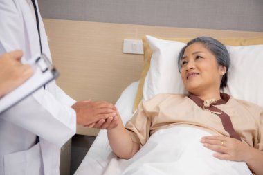 Doktorun yakın kolları hastanede yaşlı bir hastayı cesaretlendirir, doktor yaşlı hasta, teşhis hastalığı ve hastalığın tesellisi ve tıbbi konsept için el ele tutuşur..