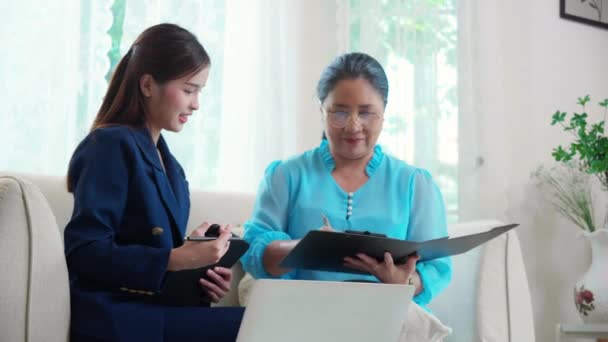 エージェント保険の生命または健康またはアドバイザー若いアジアの女性と高齢女性は リビングルームの文書に同意し署名し ビジネス 保険のコンセプトの計画 — ストック動画