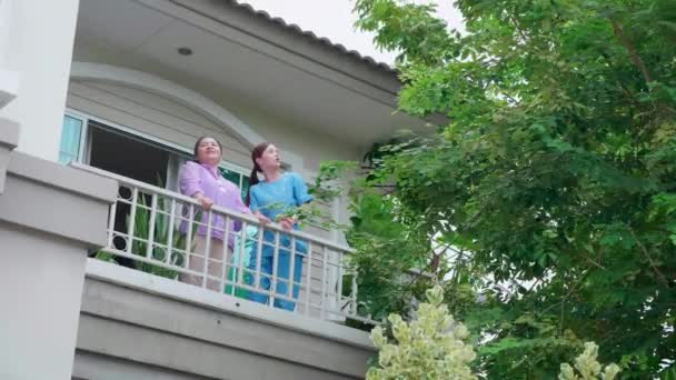 Azjatycka Opiekunka Lub Pielęgniarka Balkonie Starszą Kobietą Relaks Przytulnym Domu — Wideo stockowe