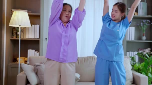 アジアの介護者女性または看護師トレーニングシニア女性は 身体療法やリハビリテーション 介護者 または高齢者のトレーニングを支援しながらスポーツボールを持ち上げます — ストック動画