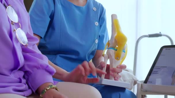 Opiekun Lub Pielęgniarka Pomaga Sprawdzić Ścięgno Artretyzm Kolana Lub Nogi — Wideo stockowe
