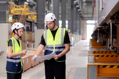Kafkasyalı genç mühendis ve kadın ya da işçi istasyon, ulaştırma ve altyapı, müfettiş ya da teknisyen kontrolleri için planlı ve elektrikli trenin bakımını kontrol ediyor..
