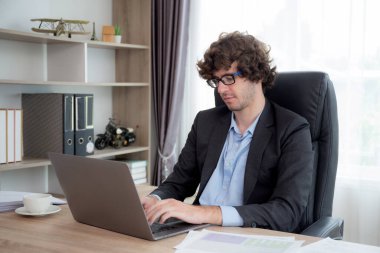 Kafkasyalı genç işadamı pazarlama için dizüstü bilgisayar planlaması kullanıyor, iş adamı not defterine yazı yazıyor ve grafiğe bakıyor, yönetici ya da yönetici ve yatırım, iş konsepti.