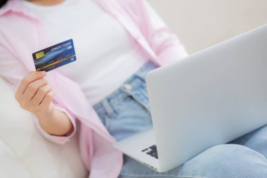 Kanepede oturan kadının elleri dizüstü bilgisayarla online alışveriş yapıyor kredi kartıyla mutlu kadın ödemeleri kanepe, satın alma ve ödeme, iş ve teknoloji konsepti.
