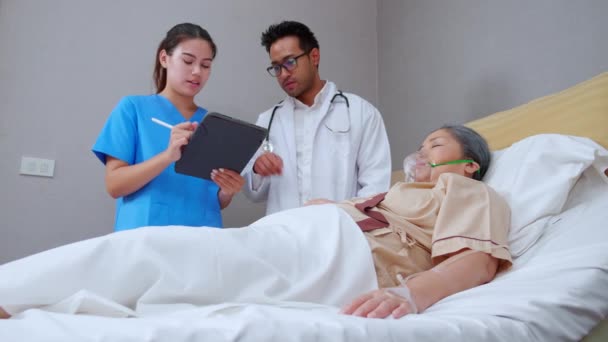 Specialista Lékař Vysvětluje Diagnostiku Zdravotní Sestrou Zatímco Starší Pacient Spí — Stock video