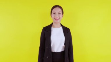 Sarı arka planda, reklamcılıkta ve pazarlamada izole edilmiş, genç Asyalı iş kadınını sunan ve gösteren portre. Kadın sürpriz ve heyecanlı, iş kadını seçimi ve ifade..