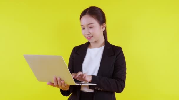 ポートレート若いアジアのビジネス女性は オンラインでインターネットにラップトップコンピュータで作業し 黄色の背景で成功 スーツのビジネスマンは ノートブック マーケティングとコミュニケーションを使用して喜んで — ストック動画