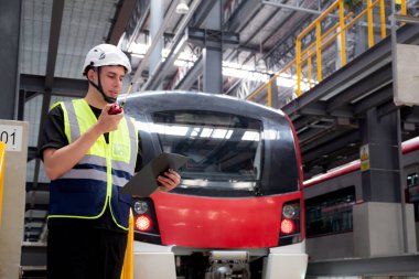 Kafkasyalı genç mühendis ya da işçi, elektrik treninin bakım ve onarım için aranması ve kontrol edilmesi ve istasyonda komuta için telsizin kullanılması nedeniyle panoyu tutuyor..