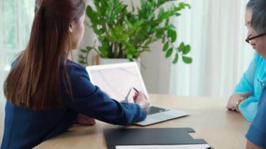 Genç Asyalı kadın, yaşlı çift ve eşe oturma odasının planlanması için sigorta hayatı hakkında danışmanlık yapıyor. Hayat sigortası acentesi ya da danışman, kararları kıdemlilere bildiriyor..