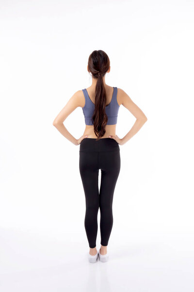 Портрет красивой молодой азиатской женщины в спортивной одежде, показывающей талию и пресс на белом фоне, спорт и упражнения для здоровья, женское похудение с уверенностью и здоровьем, вид сзади.