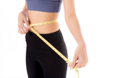 Güzel, genç Asyalı kadın kilo vermek için beliyle ölçü bandı, izole edilmiş beyaz arka plan, spor kıyafetleri içinde zayıf vücut, spor, spor ve sağlık konsepti olan kadın..