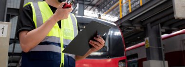 Kafkasyalı genç mühendis ya da işçi, elektrik treninin bakım ve onarım için aranması ve kontrol edilmesi ve istasyonda komuta için telsizin kullanılması nedeniyle panoyu tutuyor..