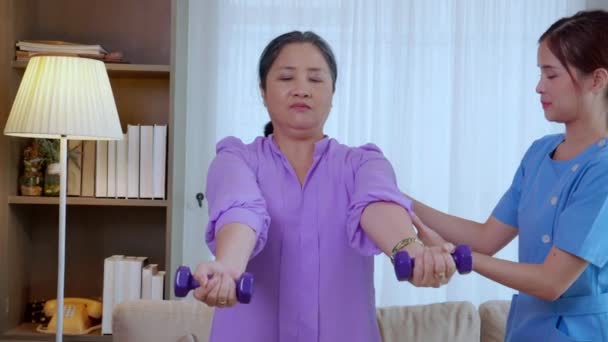 Азиатская Сиделка Медсестра Тренирует Пожилую Женщину Поднимая Гантель Упражнений Руках — стоковое видео