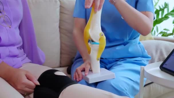 Opiekun Lub Pielęgniarka Pomaga Sprawdzić Ścięgno Artretyzm Kolana Lub Nogi — Wideo stockowe