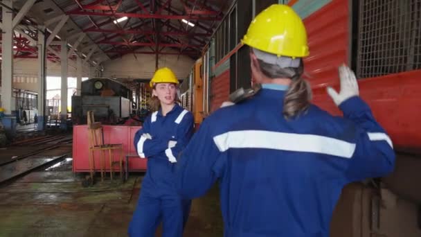 年轻的高加索工程师男子和女子步行检查火车柴油机 而高级五人与合作伙伴在车站 小组工程师检查系统运输 运输和工业 — 图库视频影像