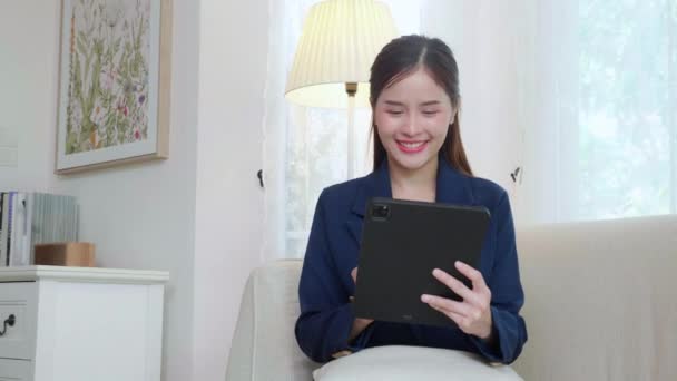 아시아의 사업가가 태블릿 컴퓨터를 사용하여 소파에 사무실에서 거실에서 사업을 비즈니스 — 비디오