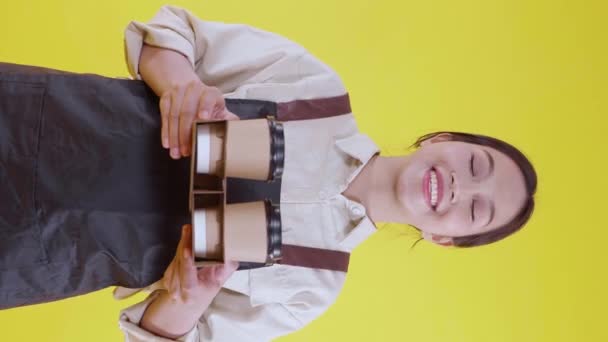 Portret Młodej Azjatyckiej Baristki Noszącej Fartuch Dającej Filiżankę Kawy Żółtym — Wideo stockowe