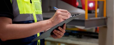 Closeup hands of engineer man or worker checking electric train for planning maintenance and writing document on clipboard in station, transport and infrastructure, inspector check service transport. clipart